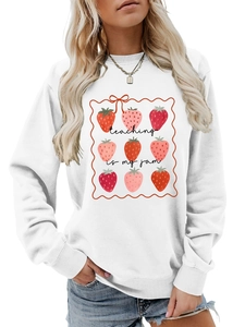 Close-up of 'teaching is my jam' text and red strawberry print on white pullover