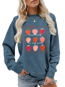 Close-up of strawberry graphics and Teaching Is My Jam text on blue sweatshirt