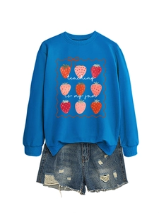 Detail of blue 'teaching is my jam' sweatshirt with strawberry print and ripped denim shorts
