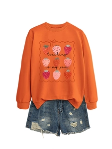 Detail of orange sweatshirt with strawberry print and distressed denim shorts set