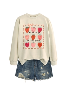 Detail of cream sweatshirt with Teaching is my jam strawberry print and denim shorts