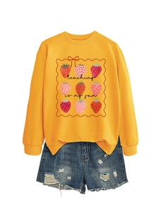 Flat lay of yellow Teaching Is My Jam sweatshirt with strawberry print and ripped denim shorts