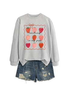 Detail of grey sweatshirt with Teaching Is My Jam slogan and strawberry illustrations