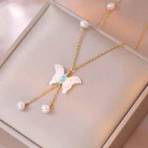 Collana dorata con ciondolo a farfalla in conchiglia bianca e perle eleganti