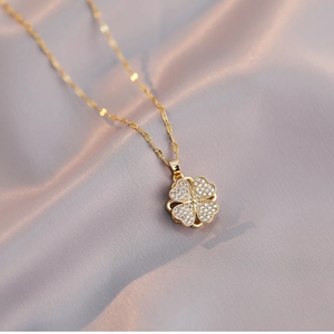 Rotating four-leaf heart necklace in gold finish with sparkling pavé crystals on silk