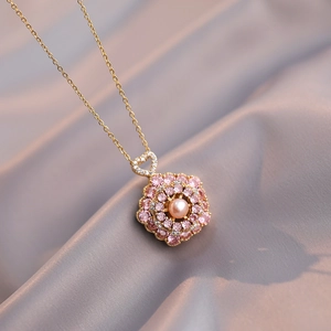Pink pearl flower pendant necklace with gold plated heart clasp on silk background