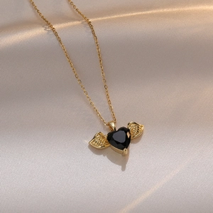 Collier élégant cœur ange doré avec zircon noir sur tissu en satin couleur champagne