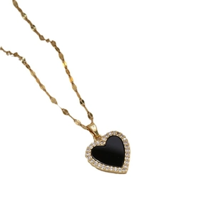 Collar de titanio dorado con colgante de corazón en esmalte negro y detalles de circón
