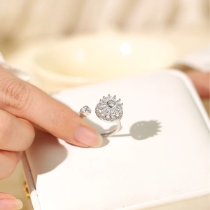 Dettaglio anello girevole a girasole regolabile in argento con zirconi scintillanti