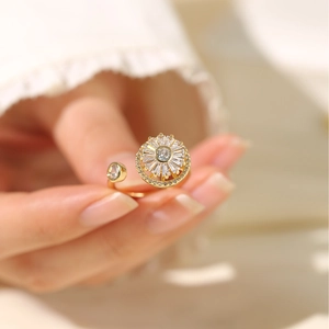 Dettaglio anello regolabile dorato con girasole in zircone scintillante su dito femminile