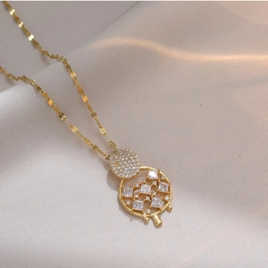 Elegant gold dreamcatcher necklace featuring sparkling zircon crystals on beige fabric
