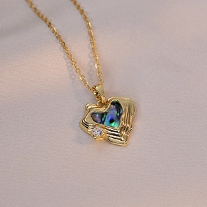 Golden heart necklace with iridescent abalone shell inlay and small zircon crystal detail