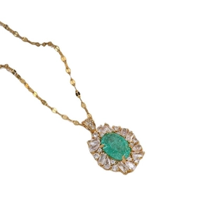 Collier vintage avec pendentif émeraude et zircons sur une chaîne en titane plaqué or