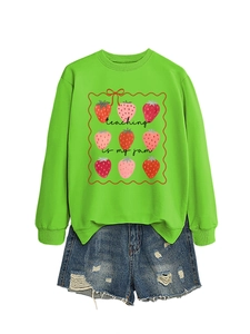 Flat lay of green sweatshirt with strawberries and Teaching Is My Jam slogan on white base