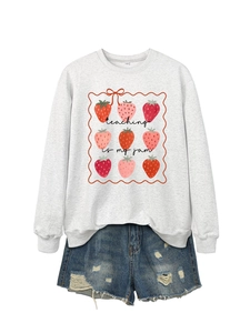 Detail of grey sweatshirt with Teaching is my Jam print and ripped denim shorts