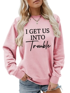 Detail eines rosa Sweatshirts mit schwarzem I GET US INTO TROUBLE Schriftzug-Aufdruck