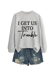 Detail eines grauen Sweatshirts mit Schriftzug und blauen Jeansshorts im Vintage-Look