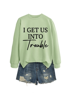 Flachbild von hellgrünem Slogan-Sweatshirt mit Distressed-Denim-Shorts für Streetwear-Look