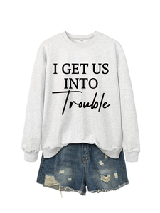 Nahaufnahme hellgraues Sweatshirt mit I GET US INTO TROUBLE Aufdruck und Denim Shorts