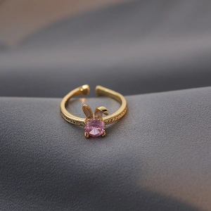 Macro detail of golden rabbit ring with pink crystal and white zircon pavé setting