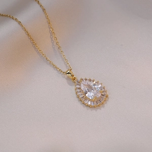 Halskette mit Wassertropfen-Zirkonia-Anhänger in Gold auf elegantem Seidenhintergrund