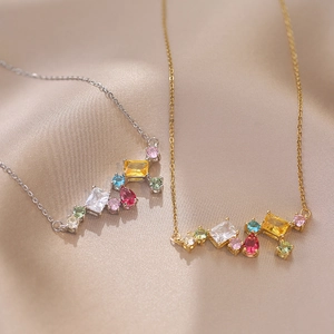 Collar brillante de circonitas de colores en oro y plata sobre tela de seda