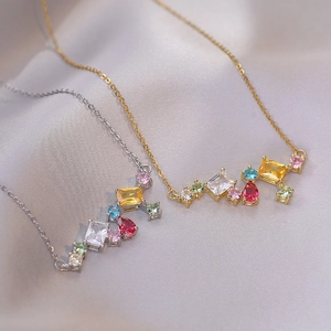Collares de circonitas de colores en oro y plata sobre fondo de seda suave