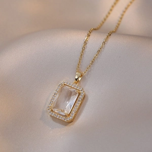 Golden titanium steel necklace with rectangular zircon pendant on silk background