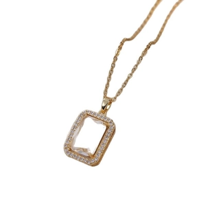 Minimalist gold titanium necklace with a geometric zircon pendant on white background