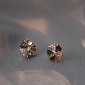 Boucles d'oreilles fleurs en zircone colorée plaquées or sur fond de satin gris doux