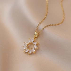 Elegant gold flower wreath necklace with marquise-cut cubic zirconia on satin backdrop