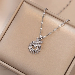 Détail du pendentif tournesol avec zircons et chaîne argentée sur boîte à bijoux