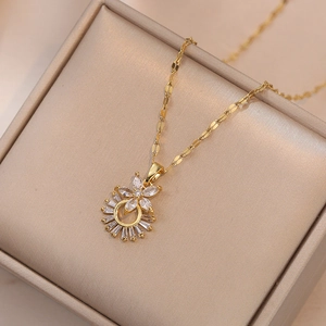 Détail d'un collier doré avec pendentif floral et zircons posé sur du satin de champagne