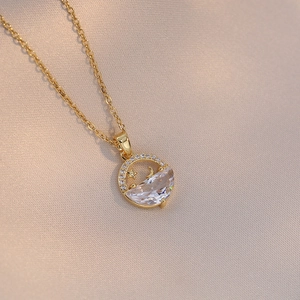 Détail du collier doré avec pendentif lune et étoile et zircons sur soie