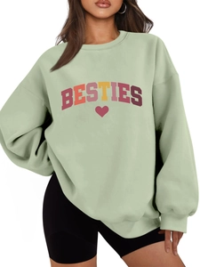 Detail of sage green oversized sweatshirt featuring colorful BESTIES text and heart print