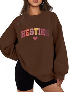 Detail of BESTIES letter print and heart graphic on coffee brown oversized sweatshirt