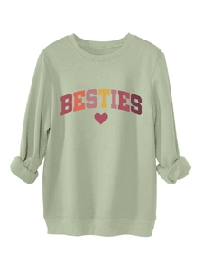 Detail of light green sweatshirt fabric showing soft fleece lining and BESTIES print