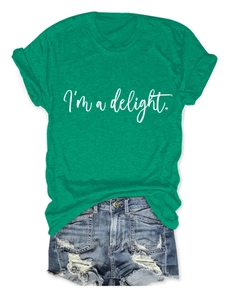 Flat lay of a green crewneck T-shirt with I'm a delight print and ripped denim shorts