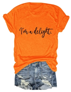 Flat lay of an orange crewneck T-shirt with 'I'm a delight' print and denim shorts