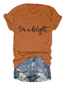 Flat lay of women's orange crew neck t-shirt with I'm a delight slogan and denim shorts