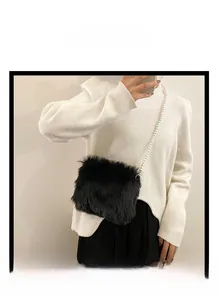 Détail d'un sac à bandoulière en fausse fourrure noire avec chaîne en perles blanches