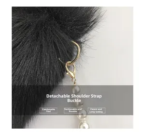 Détail d'un pompon en peluche noir avec chaîne en perles blanches et fermoir doré