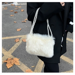 Détail d'un sac bandoulière en fausse fourrure blanche avec anse en perles élégante