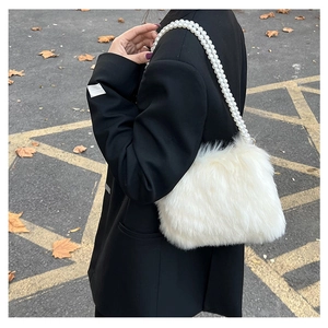 Sac bandoulière en peluche blanche avec anse perles porté par un mannequin en ville