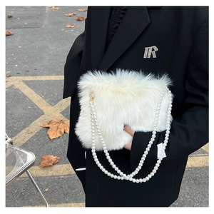 Gros plan détaillé d'un sac bandoulière en peluche blanche avec chaîne de perles élégante