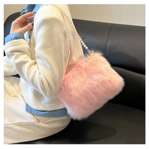 Détail du sac bandoulière en fausse fourrure rose avec chaîne de perles et fermoir doré