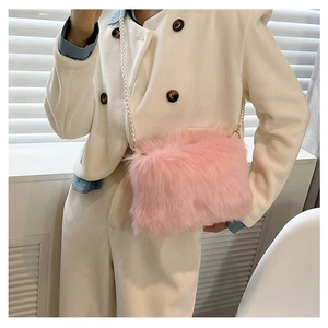 Gros plan du sac bandoulière en fausse fourrure rose avec chaîne de perles blanches