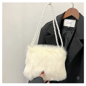 Détail du sac bandoulière en fausse fourrure blanche avec brides en perles et texture douce