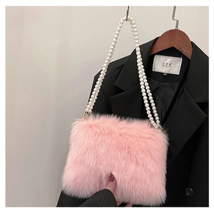 Détail du sac bandoulière en fausse fourrure rose avec texture douce et bandoulière en perles
