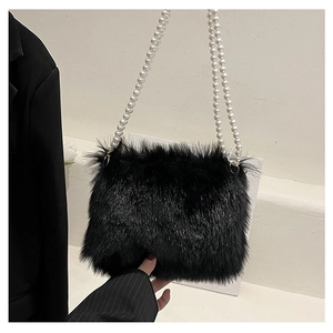 Gros plan d'un sac bandoulière en peluche noire avec d'élégantes anses en perles